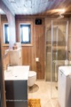 Nice and heated bathroom with sink, shower, toilet and washing machine.